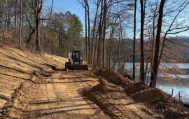 A crewmember from the Dalton Public Works Department works to clear a path for the paving project in Haig Mill Lake Park