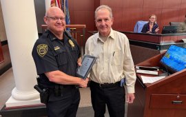 Assistant Police Chief Chris Crossen (left) shakes hands with Dalton Elks Lodge Trustee Vance Rhodes (right) after receiving a c