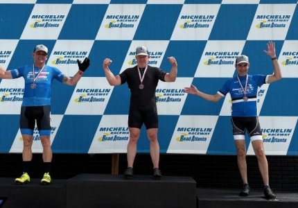 Dalton firefighter Douglas Kerns (left) stands on the awards podium after finishing second in the cyclinc competition at the Mic