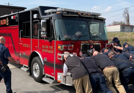 Firefighters Push A New Fire Truck Into A Fire Station