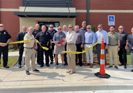 Mayor Annalee Sams (center) cuts a piece of crime scene tape to officially dedicate the new Property and Evidence building