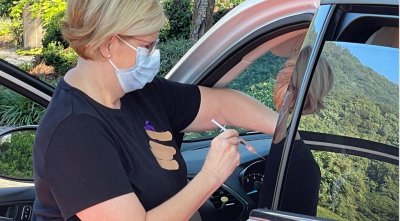 a nurse administers a vaccine dose at a drive-thru clinic