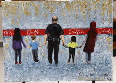 A painting given to Officer Smith depicts him holding hands with students 