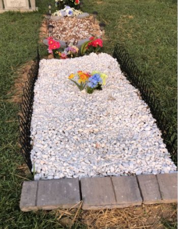 A non-complying gravesite covered in gravel