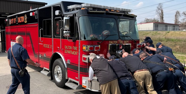 Firefighters Push A New Fire Truck Into A Fire Station