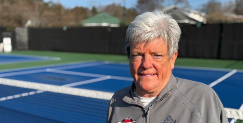 A portrait of DPRD Tennis and Pickleball Director Michel Bates on a tennis court 