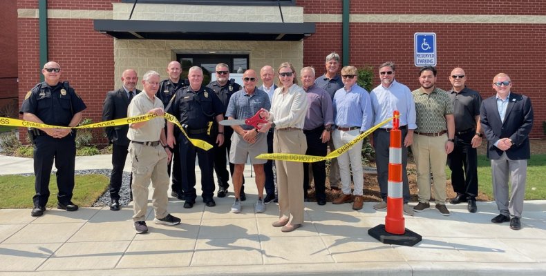 Mayor Annalee Sams (center) cuts a piece of crime scene tape to officially dedicate the new Property and Evidence building
